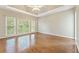 Primary bedroom featuring hardwood floors, tray ceiling, and large windows at 1740 Manhasset Pl, Atlanta, GA 30338