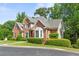 Front exterior of the home featuring brick, bay windows, and manicured landscaping at 1740 Manhasset Pl, Atlanta, GA 30338