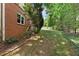 Side yard of the home with lush greenery and a brick exterior wall at 1740 Manhasset Pl, Atlanta, GA 30338