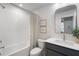 Modern bathroom with white subway tile, shower-tub combo, and a stylish vanity with an arched mirror at 200 Pinecone Pl, Alpharetta, GA 30022