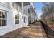 Exterior view of homes, each with white painted brick, well-maintained grounds, and dark metal fencing at 200 Pinecone Pl, Alpharetta, GA 30022