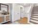 Hallway featuring white walls, light wood floors, and a decorative cabinet at 200 Pinecone Pl, Alpharetta, GA 30022