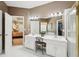 Dual sink vanity featuring a decorative chair and shower with glass door at 2545 Amberbrook Ln, Grayson, GA 30017