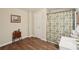 Compact bathroom features wood-look flooring, small storage unit, and patterned shower curtain at 2545 Amberbrook Ln, Grayson, GA 30017