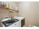 Well-equipped laundry room with modern washer, dryer, and storage shelves at 2545 Amberbrook Ln, Grayson, GA 30017