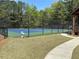 Well-maintained community tennis court surrounded by a tall fence and lush greenery at 2545 Amberbrook Ln, Grayson, GA 30017