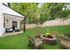 Well-maintained backyard featuring a patio with seating, a lush lawn, and a charming fire pit area with wooden chairs at 2896 Lakemont Sw Dr, Marietta, GA 30060