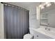 Bathroom featuring a shower with blue curtain, toilet, white vanity, mirror, overhead storage, and a window at 2896 Lakemont Sw Dr, Marietta, GA 30060