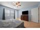 A large flat screen TV sits atop a wooden dresser in a bedroom with light blue walls and a ceiling fan at 2896 Lakemont Sw Dr, Marietta, GA 30060