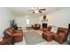 A bright living room with tile floor, a fireplace, ceiling fan, and comfortable leather seating at 2896 Lakemont Sw Dr, Marietta, GA 30060