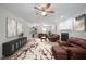 A spacious living room featuring a fireplace, ceiling fan, plush seating, and elegant decor at 2896 Lakemont Sw Dr, Marietta, GA 30060