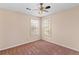 Empty bedroom with tan walls, carpet, ceiling fan, and natural light from the windows at 65 Woodside Ct, Mcdonough, GA 30253