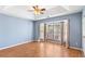 Spacious bedroom featuring a tray ceiling, ceiling fan, large windows, and wood-look floors at 65 Woodside Ct, Mcdonough, GA 30253