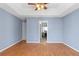 Bedroom with a tray ceiling, ceiling fan, blue walls, and wood-look floors at 65 Woodside Ct, Mcdonough, GA 30253