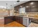 Kitchen with stainless steel appliances, dark cabinets, granite countertops and pendant lighting at 65 Woodside Ct, Mcdonough, GA 30253