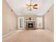 Bright living room with a stone fireplace, neutral carpet, and lots of natural light at 65 Woodside Ct, Mcdonough, GA 30253