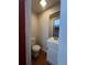 This half-bathroom has tile floors, a toilet, sink, and mirror at 1228 Reilly Ln, Clarkston, GA 30021