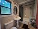 This bathroom has tile floors, a toilet, sink, mirror, and shower with curtains at 1228 Reilly Ln, Clarkston, GA 30021