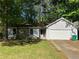 Charming single-story home with a stone facade, attached garage, and lush green lawn at 1228 Reilly Ln, Clarkston, GA 30021