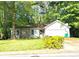 Charming home exterior with stone accents, a front yard, and surrounded by trees at 1228 Reilly Ln, Clarkston, GA 30021