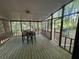 Enclosed screened porch with dining set and access to an outdoor area with grill at 1228 Reilly Ln, Clarkston, GA 30021