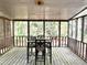 Relaxing screened porch with wood flooring and table with seating, perfect for outdoor enjoyment at 1228 Reilly Ln, Clarkston, GA 30021