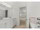 Light-filled bathroom with double sinks, vanity, and a glimpse into a bedroom area through an open doorway at 13579 Whitman Ln, Covington, GA 30014