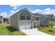 Modern two-story home with a two-car garage, gray siding, and a well-maintained lawn at 13579 Whitman Ln, Covington, GA 30014