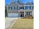 Charming two-story home with a two-car garage, brick accents, and a well-manicured lawn at 13579 Whitman Ln, Covington, GA 30014