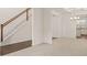 Spacious living room featuring a staircase, modern light fixture and connection to kitchen at 13579 Whitman Ln, Covington, GA 30014