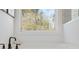 Bright bathroom with soaking tub with black fixtures and large window overlooking nature at 2718 Byess Ct, Marietta, GA 30064