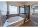 Beautiful bathroom with a large tub, shower, decorative window and tiled walls at 10 Edgewater Ct, Covington, GA 30016