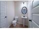 Powder room with a pedestal sink, toilet, oval mirror, and good lighting at 10 Edgewater Ct, Covington, GA 30016