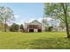 Large grassy backyard featuring lush lawn, mature trees, and exterior view of home's screened-in back porch at 106 Thornwood Dr, Woodstock, GA 30188