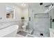 Modern bathroom showcasing a glass-enclosed shower with marble tiling and a freestanding soaking tub for a spa-like experience at 106 Thornwood Dr, Woodstock, GA 30188