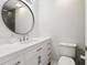 Clean half-bathroom with modern vanity, mirror, and sink, providing a stylish and functional space for guests at 106 Thornwood Dr, Woodstock, GA 30188