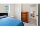 Cozy bedroom showcasing a blue quilt, natural light and wood dresser at 106 Thornwood Dr, Woodstock, GA 30188