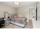 Cozy bedroom with neutral walls, light hardwood floors, and soft pink pillows to create a relaxing and inviting atmosphere at 106 Thornwood Dr, Woodstock, GA 30188