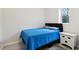 Simple bedroom with blue comforter, white nightstand, and neutral decor at 106 Thornwood Dr, Woodstock, GA 30188