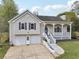 Charming home featuring a covered front porch, well-manicured lawn, and attached two-car garage at 106 Thornwood Dr, Woodstock, GA 30188