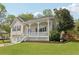 Charming home featuring a covered front porch, well-manicured lawn, and attached two-car garage at 106 Thornwood Dr, Woodstock, GA 30188
