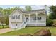 Charming home featuring a covered front porch, well-manicured lawn, and attached two-car garage at 106 Thornwood Dr, Woodstock, GA 30188