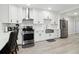 Bright kitchen features stainless steel appliances, white cabinetry, and modern design for a clean, functional cooking space at 106 Thornwood Dr, Woodstock, GA 30188
