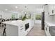 White kitchen with a large center island and views to the dining and living areas at 106 Thornwood Dr, Woodstock, GA 30188