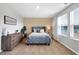 Cozy bedroom featuring a tufted blue bed frame, a wooden dresser, and light-filled windows at 319 Overlook Rd, Covington, GA 30014