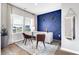 Bright home office featuring stylish decor, including a blue accent wall and natural light from large windows at 319 Overlook Rd, Covington, GA 30014