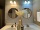 Bathroom featuring a double sink vanity and two decorative, round mirrors at 3627 Mcclaren Way, Lawrenceville, GA 30044