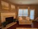 Cozy living room with a fireplace, neutral-toned sofa, and large window offering natural light at 3627 Mcclaren Way, Lawrenceville, GA 30044