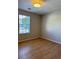 Bright bedroom featuring wood floors, a large window, and a modern ceiling light at 6213 Marbut Farms Chase, Lithonia, GA 30058