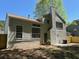 View of the rear exterior of the house, with a well-kept yard and mature trees at 6213 Marbut Farms Chase, Lithonia, GA 30058